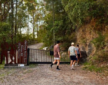 group of tourists entering the gateway to the start of walking devines hill