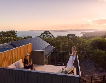 guests enjoy sunset on a lodge rooftop balcony with national park views