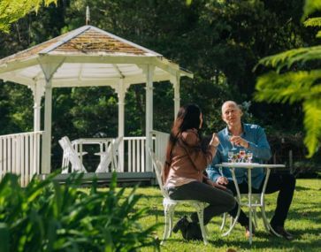 Couple sitting in the garden at Firescreek Botanical Winery, Holgate, Central Coast, NSW